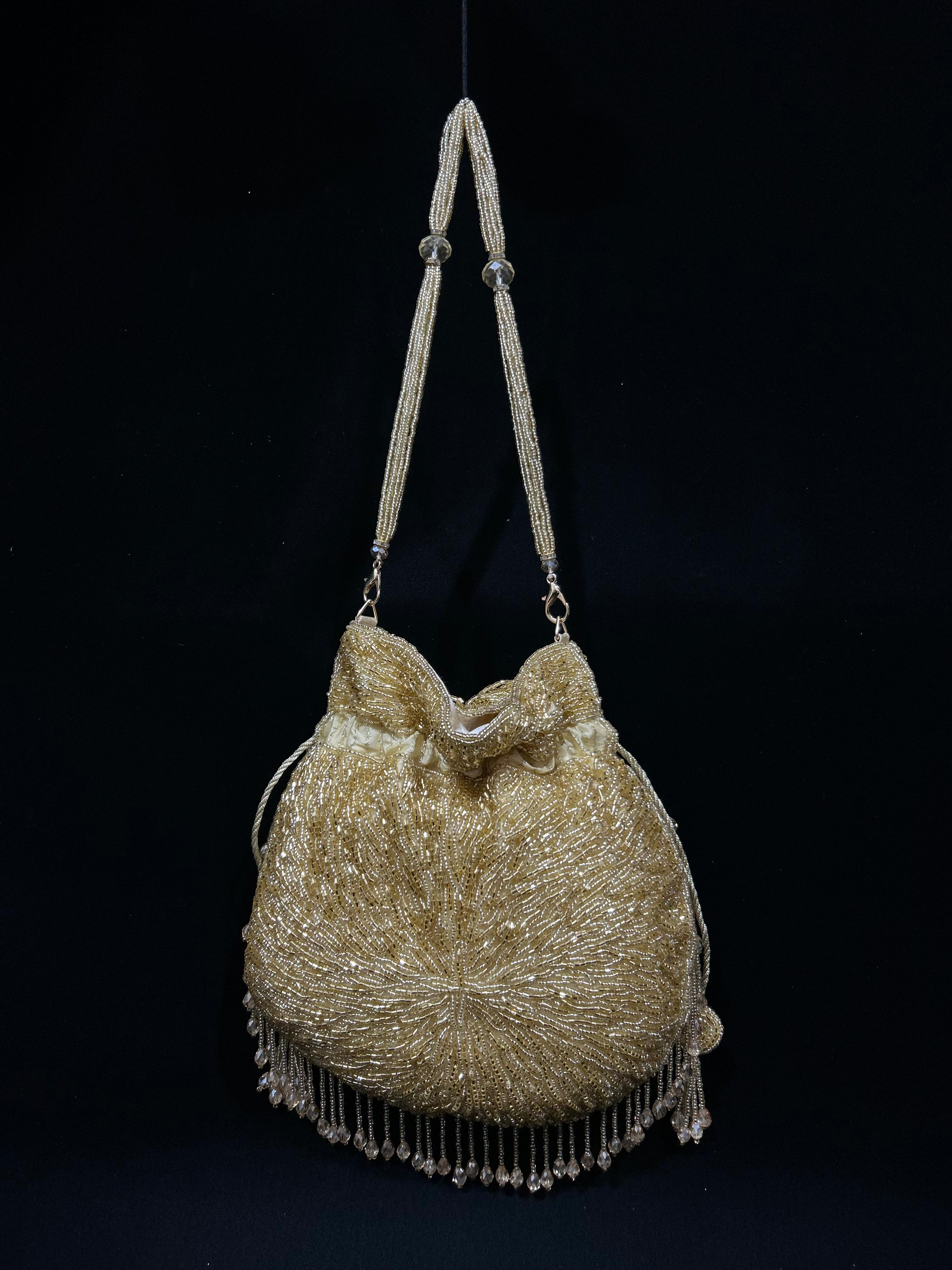 Gold beaded handbag with fringe on a black background
